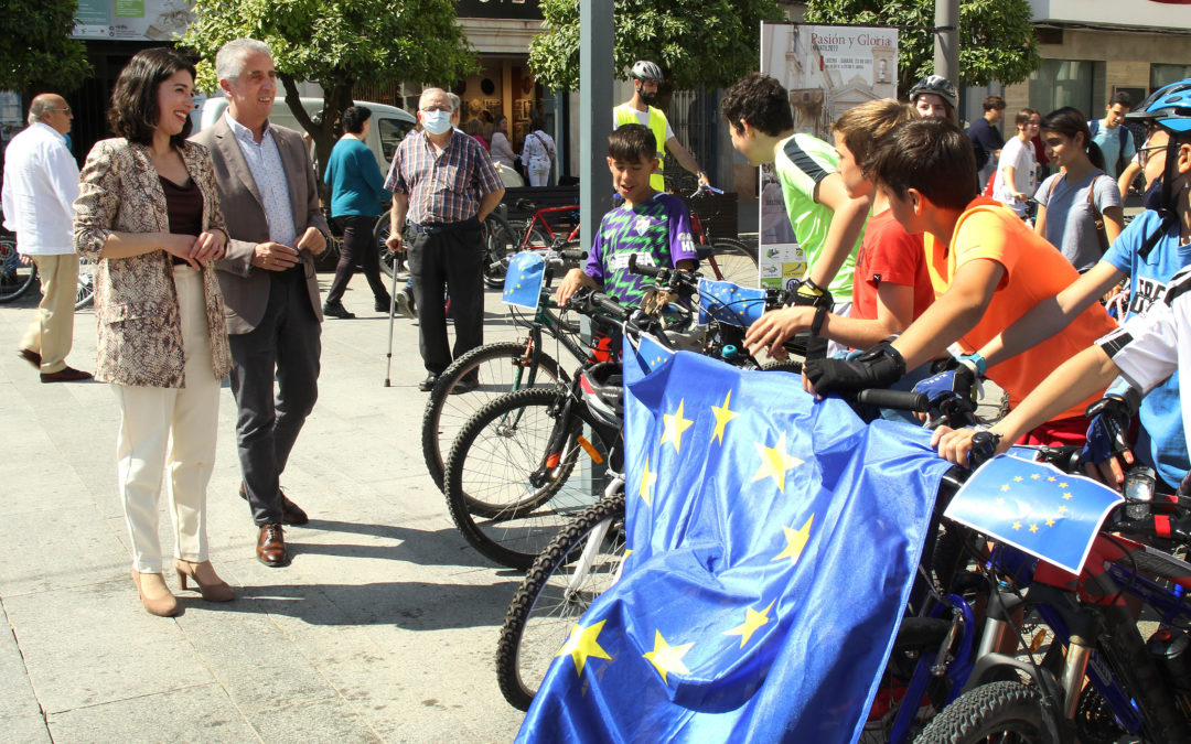 Juan Pérez y Teresa Alonso conversan con los menores en la Plaza Nueva antes de la ruta en bici